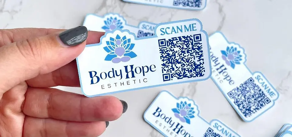 A minimalist matte sticker next to a vibrant holographic sticker, showing different brand personalities
